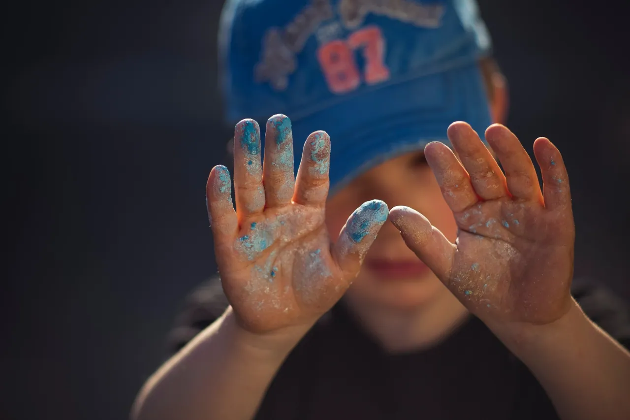 Mains d’enfant couvertes de peinture